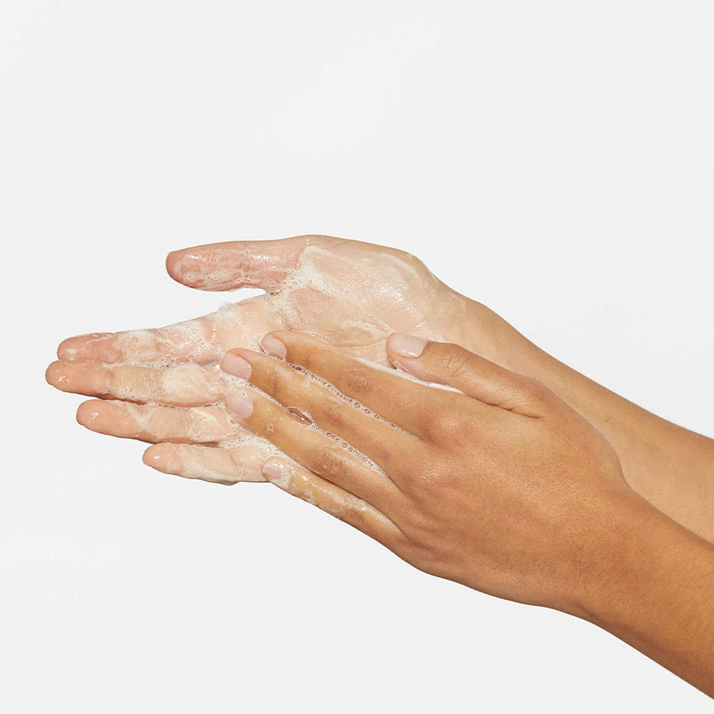 Hands with milkfoliant lather on a plain background
