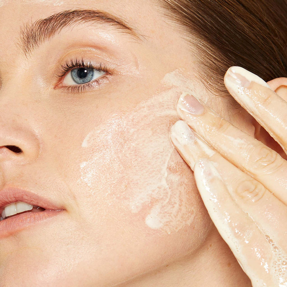 Close-up of a person applying milkfoliant to their face