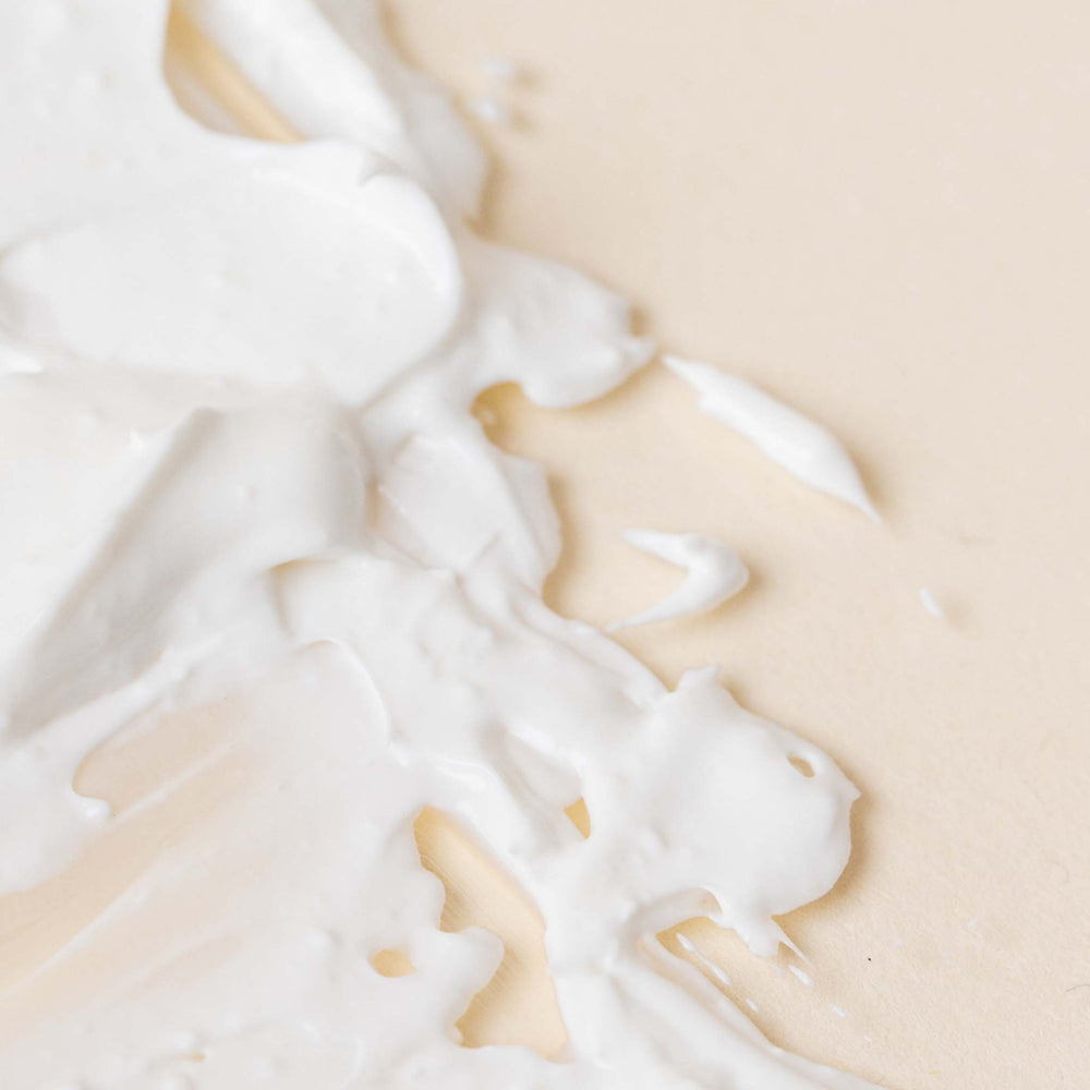 Close-up of white cream or milk on a beige background