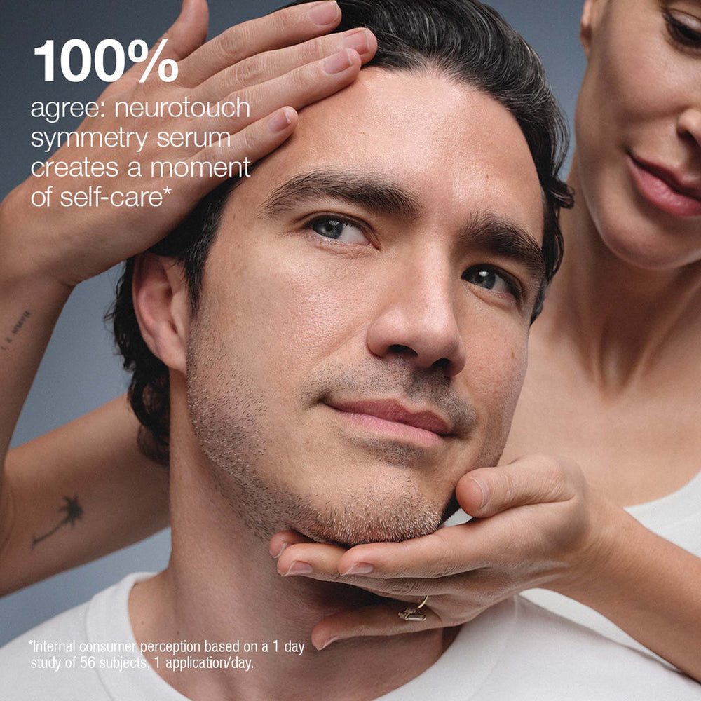 Man with a woman's hands gently touching his face, promoting neurotouch symmetry serum.