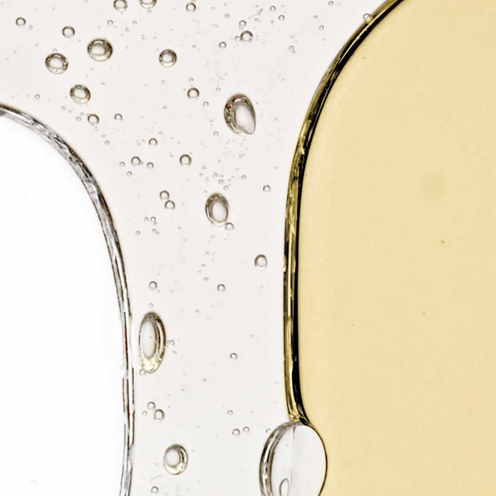 Close-up of a glass with a phyto nature serum and bubbles on a white background