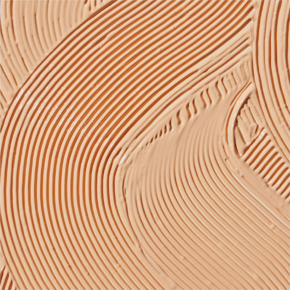 Close-up of beige makeup swatch with wavy lines